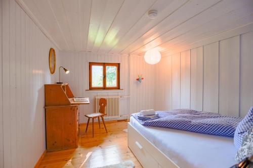 a bedroom with a bed and a desk in a room at Schlierseehaus in Schliersee