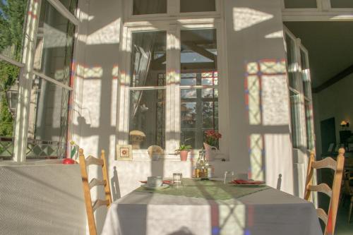 a table with a white table cloth on a room with windows at Pension Haus Marga in Wernigerode