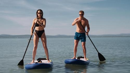 a man and a woman on paddle boards in the water at Royal Mediterran in Siófok