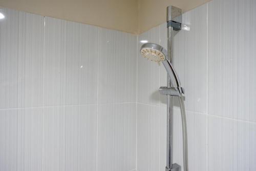een douche met een douchekop in de badkamer bij RedDoorz near Lippo Plaza Buton in Baubau