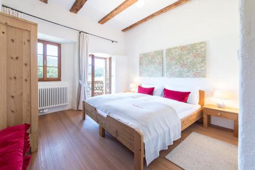 a bedroom with a large bed with red pillows at Hofbauer in Brunico