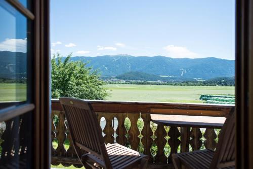 a balcony with two chairs and a view of the mountains at Hofbauer in Brunico