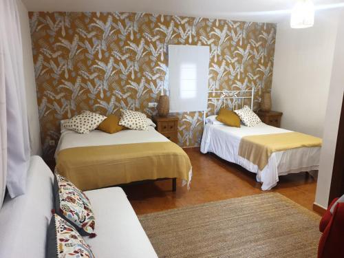 um quarto com duas camas e um sofá em El Bodegon de Luis em Hinojedo