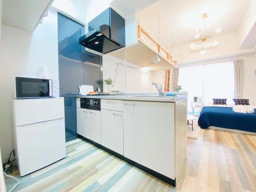 a kitchen with white cabinets and a microwave at OUCHI HOTEL Otemachi in Hiroshima