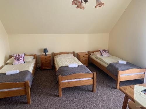 a room with three beds and a table at Willa Karolina in Czorsztyn