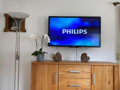 a flat screen tv sitting on top of a wooden cabinet at Ferienwohnung Apartment Haus Ager in Thiersee