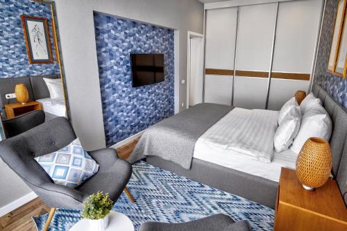 a bedroom with a bed and a couch and a chair at WOW EuApartments in Grodno
