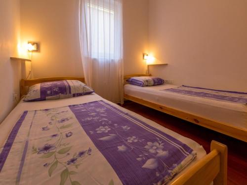 two twin beds in a room with a window at Apartment Villa Sara in Dramalj