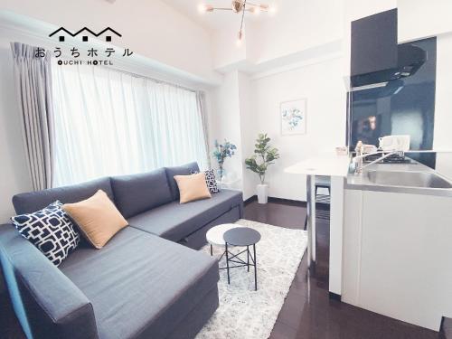 a living room with a couch and a kitchen at OUCHI HOTEL Otemachi in Hiroshima