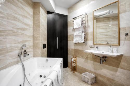 a bathroom with a tub and a sink at WOW EuApartments in Grodno