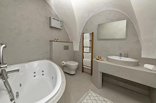 a bathroom with a tub and a sink and a toilet at DOMA u nás Boutique hotel & spa in Poprad