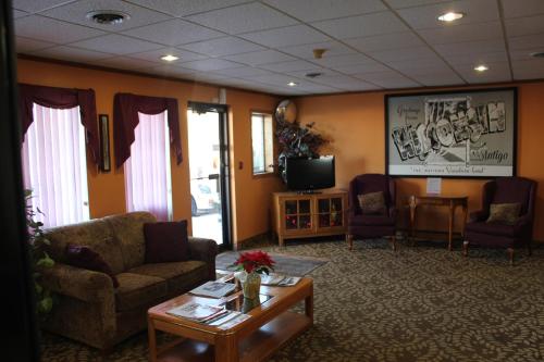 a waiting room with chairs and a tv and a table at Super 8 by Wyndham Antigo in Antigo