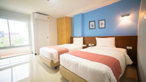 a hotel room with two beds and a window at The Willing Hotel and Residence in Lak Si