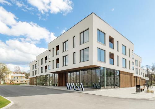 un edificio de oficinas con ventanas de cristal en una calle en Wasa Resort Hotel, Apartments & SPA, en Pärnu