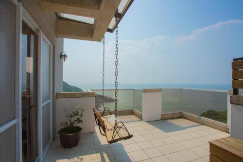 a balcony with a bench and a view of the ocean at YUN-JIN Villa Matsu in Nangan