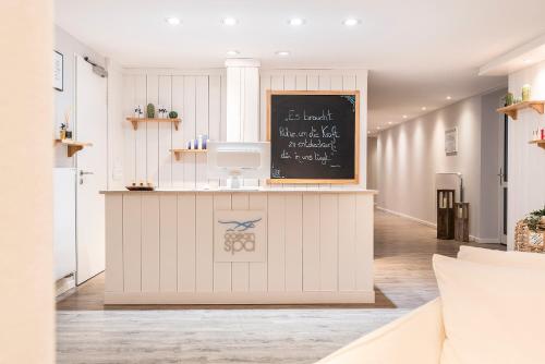 a kitchen with a counter with a chalkboard on the wall at Beach Motel St. Peter-Ording in Sankt Peter-Ording