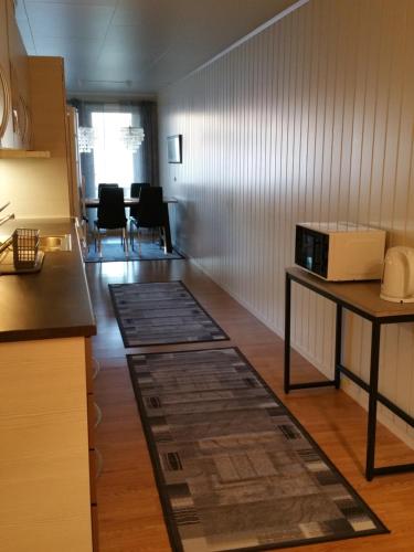 a kitchen with a counter and a table with a microwave at Hansnes Havfiske in Hansnes