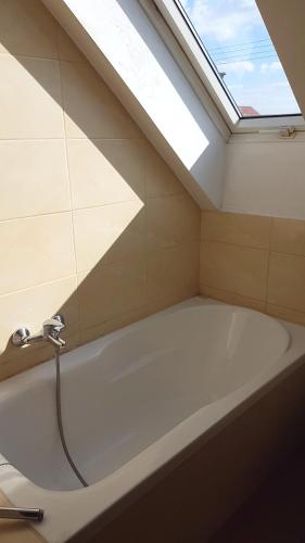 a bath tub in a bathroom with a skylight at E&S_ Apartament in Milicz