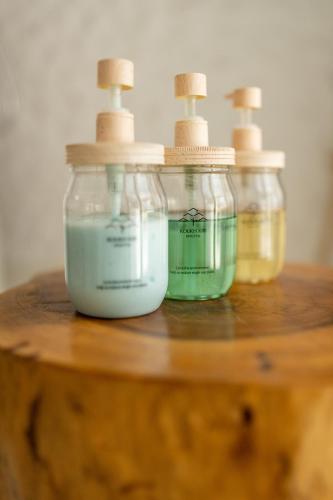 three glass jars sitting on top of a wooden table at Roukh Kiri Khaoyai, The Centara Collection in Pak Chong