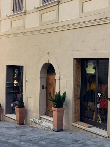 un edificio con 2 ventanas y una puerta de madera en Stefania Townhouse, en Montepulciano