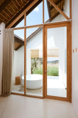 a bathroom with a tub through a window at Roukh Kiri Khaoyai, The Centara Collection in Pak Chong