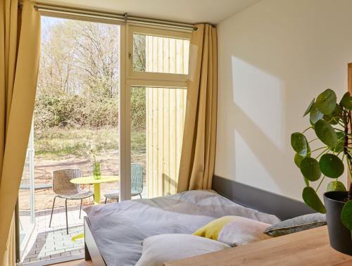 een slaapkamer met een bed en een glazen schuifdeur bij Modern ausgebauter Überseecontainer als Tiny House in Wertheim