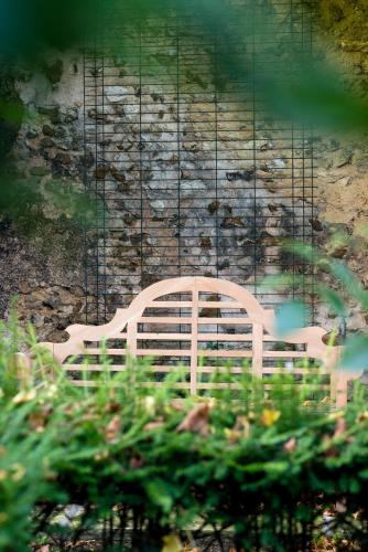 a white chair sitting in front of a stone wall at Maison Ailleurs in Chartres