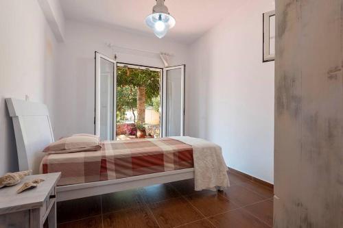 a bedroom with a bed and a large window at Ktima Sfakia in Kefalos