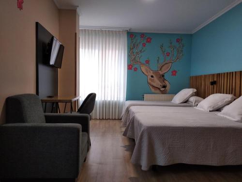 een hotelkamer met 2 bedden en een hertenkop aan de muur bij Hostal Bríos in Lugo