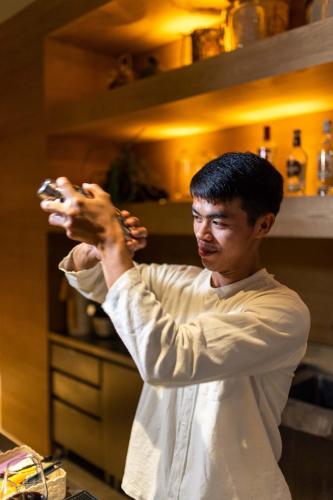 a man standing in a kitchen adjusting his hair at Roukh Kiri Khaoyai, The Centara Collection in Pak Chong