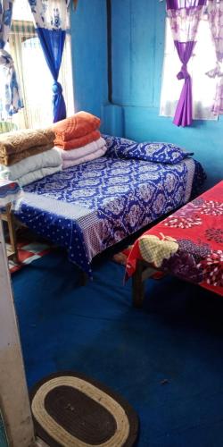 Habitación azul con 2 camas y ventana en Vamoose Bidyasagar, en Sombāri