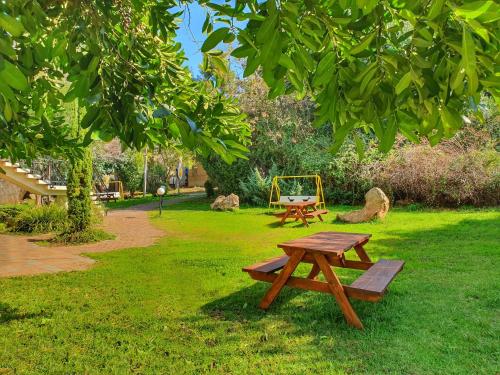 uma mesa de piquenique e um baloiço num parque em Travel Hotel Eilon em Elon