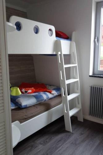 a white bunk bed with a ladder in a room at Schönes Ferienhaus in Maasholm Bad, Ostsee in Maasholm