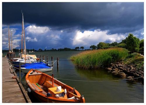 two boats docked at a dock on a lake at Schönes Ferienhaus in Maasholm Bad, Ostsee in Maasholm