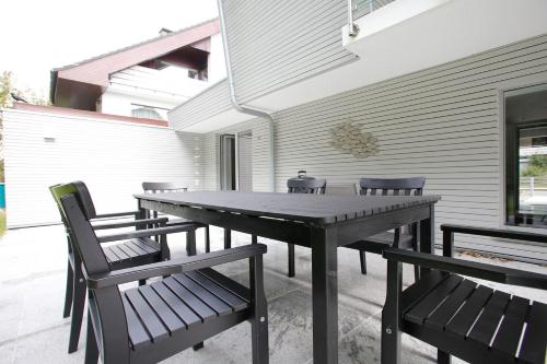 a wooden table and chairs on a patio at Schönes Ferienhaus in Maasholm Bad, Ostsee in Maasholm