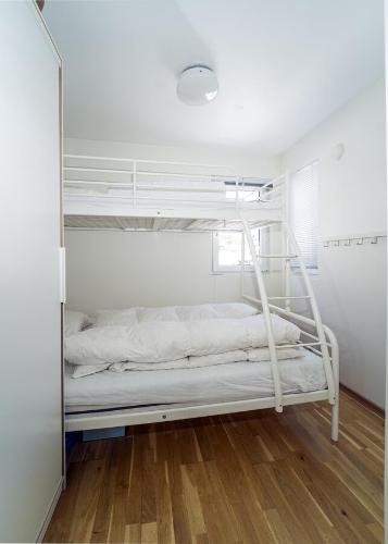 a white bunk bed in a room with a mirror at Three-Bedroom Apartment in Tjørhom