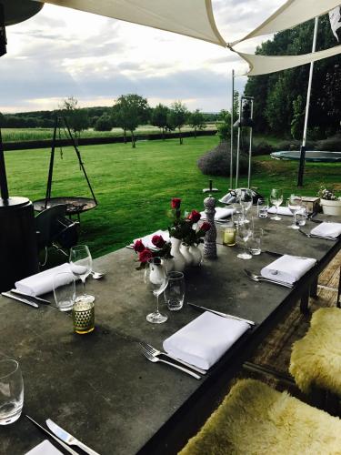 a table with wine glasses and napkins and a field at B&B Le Rêve Maastricht in Maastricht