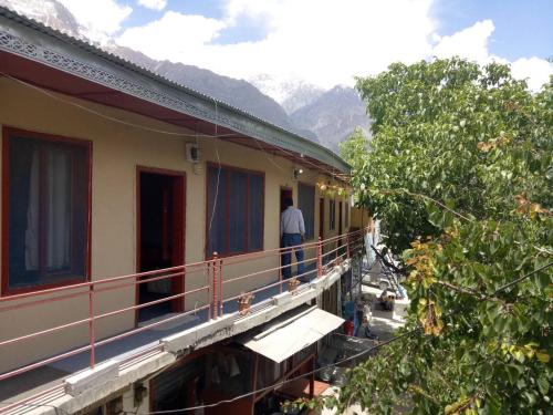 a man standing on a balcony of a building at Ali Boq Hotel & Restaurant in Hunza Valley