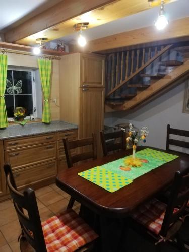 a dining room with a table and a kitchen at Chalupa Barborka in Stará Bystrica