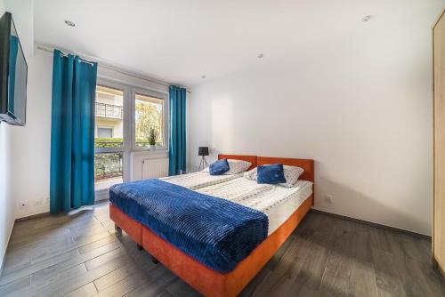 a bedroom with a large bed with blue pillows at Apartament Dominika in Jurata