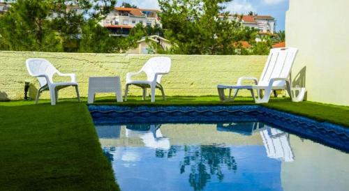 un grupo de sillas sentadas junto a una piscina en Yaakov's Apartment, en Migdal Ha‘Emeq