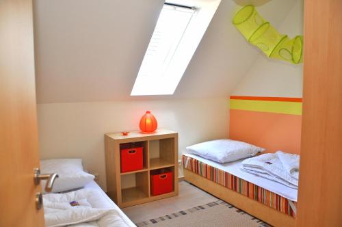Marienfelde的住宿－Ferienhaus Müritzsonne / OG-Appartement，小房间设有两张床和天窗