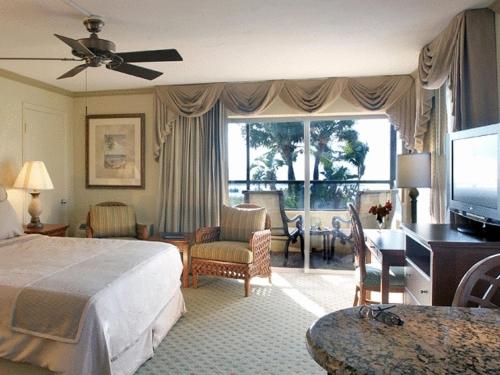 a hotel room with a bed and a television at Tween Waters Island Resort & Spa in Captiva