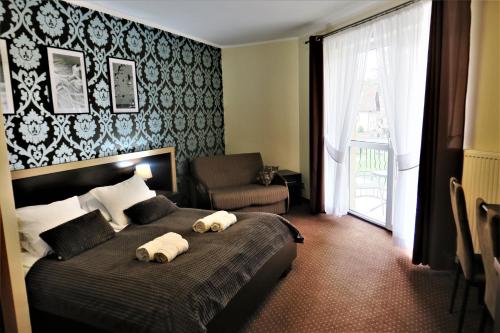 1 dormitorio con 1 cama con 2 toallas en Pensjonat Albatros Pogorzelica en Pogorzelica