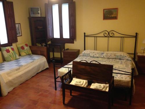 1 dormitorio con 1 cama y 1 silla con toallas en Agriturismo La Marletta, en Imola