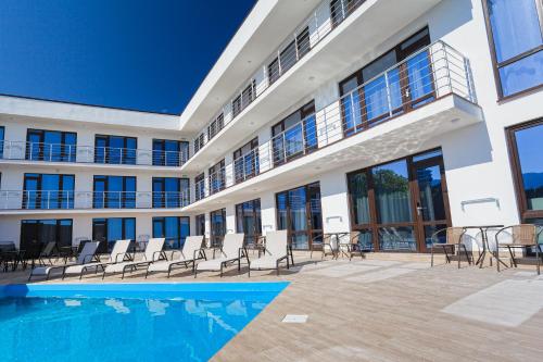 an apartment building with a swimming pool and chairs at Sun Ray in Yalta