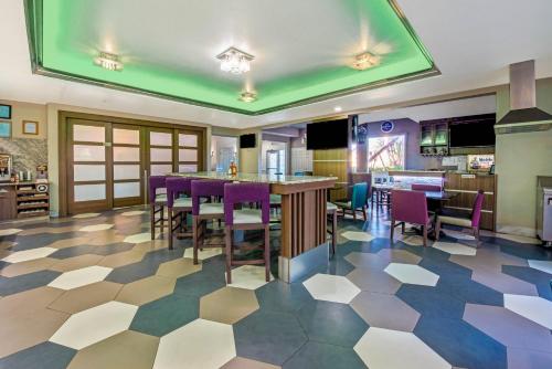 a dining room with a table and purple chairs at La Quinta Inn & Suite Kingwood Houston IAH Airport 53200 in Kingwood
