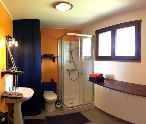 een badkamer met een douche, een toilet en een wastafel bij Le repaire des Belettes in Chaux-des-Crotenay