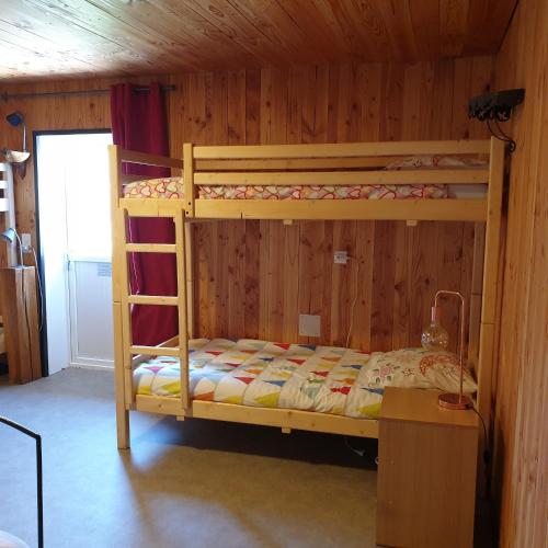 a bedroom with two bunk beds in a wooden wall at Mas de Reilhanette in Montbrun-les-Bains