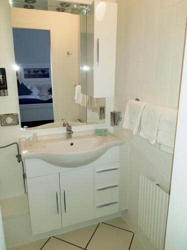a white bathroom with a sink and a mirror at Villa zur schönen Aussicht in Bad Salzuflen